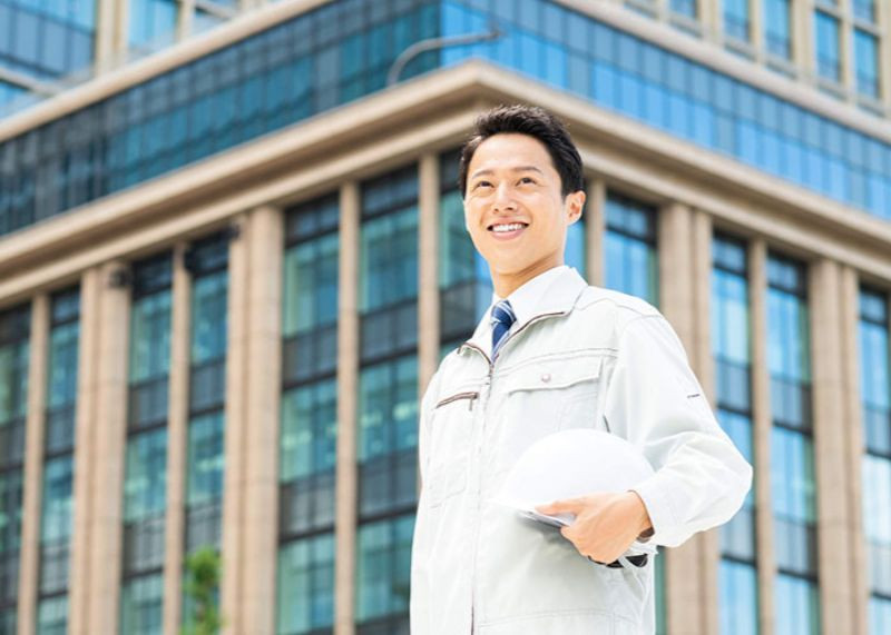 ヘルメットを持っている作業服の男性